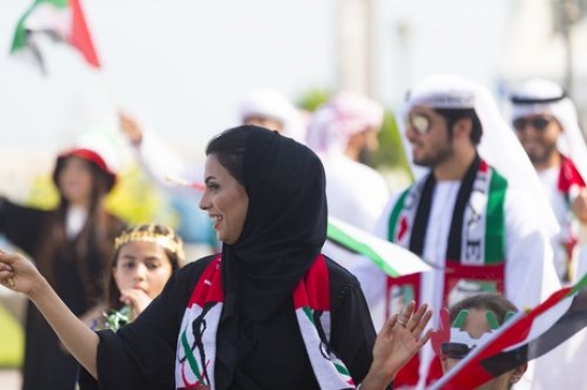 Medium shot of an arab woman during a National Day parade|