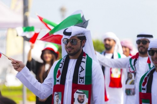 Arab man with a group of people celebrating National Day|