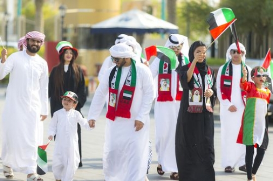 A group of family and friends at a National Day parade representing their country|