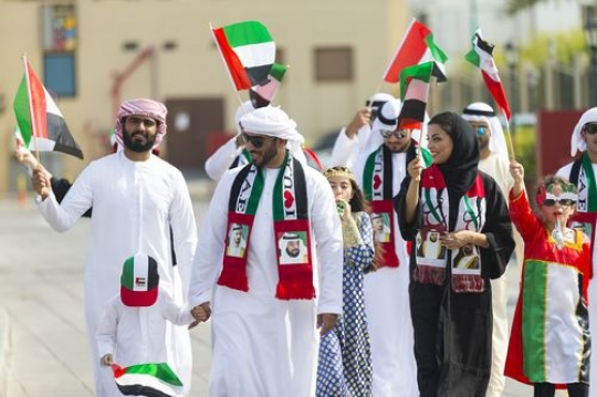Arabian family and friends at a parade celebrating National Day|