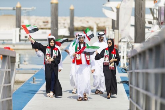 Arab men and woman dressed in the traditional attire celebrating UAE National Day|