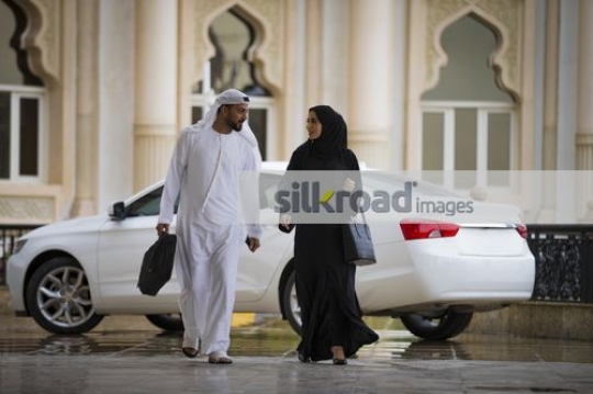 Two colleagues walking together talking business|