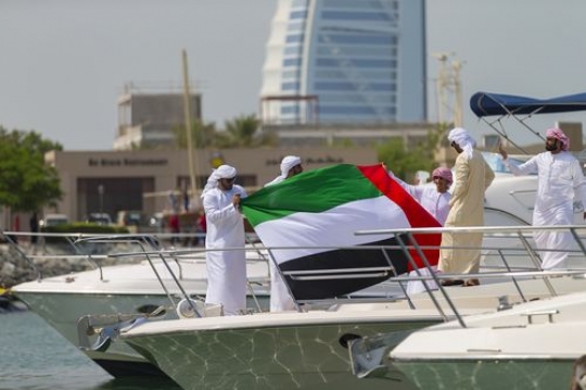 Arab men celebrating National Day on a Yacht|