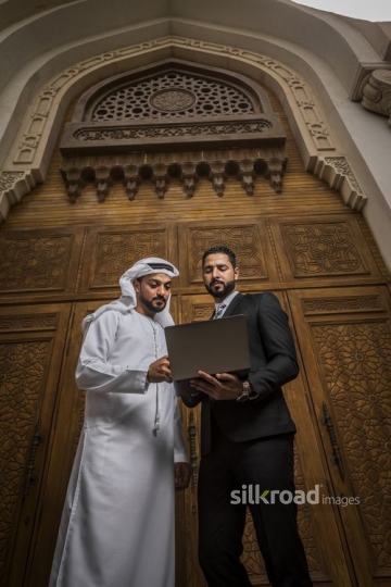 Middle Eastern Businessmen standing together using the laptop|-