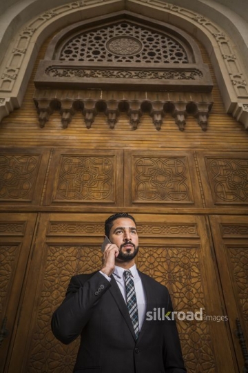 Medium shot an Arab businessman using his mobile|-