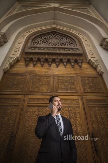 Businessman standing using his mobile|-