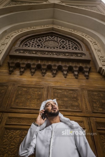 Medium shot of a Middle Eastern Businessman using his mobile|-
