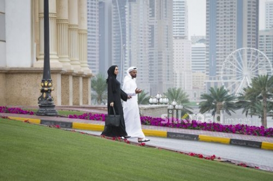 Middle Eastern businessman and business woman talking to each other|-