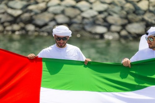 Arab men representing their country while holding a UAE Flag|