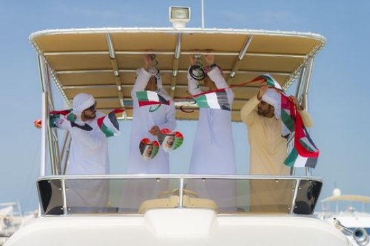 A group of men decorating the yacht for the UAE National Day|