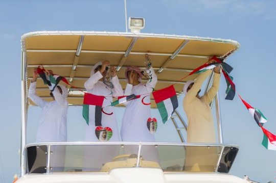 Arab men decorating the yacht for National Day|