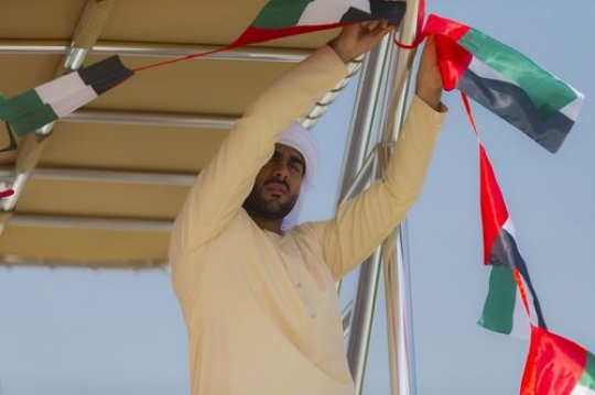 Arab man decorating the Yacht for celebrations of the UAE National Day|