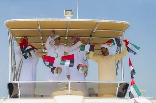 A group of men decorating the Yacht for celebrations of the UAE National Day|