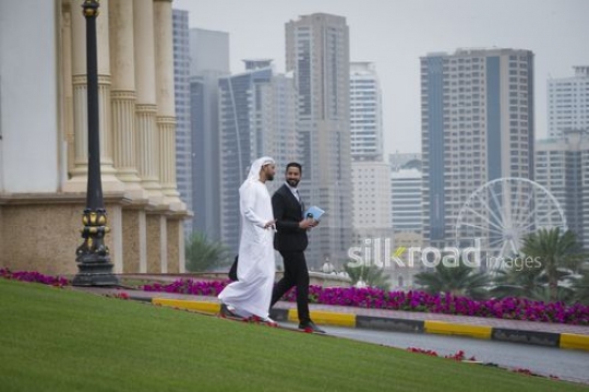 Arab Businessmen walking outside talking to each other|-
