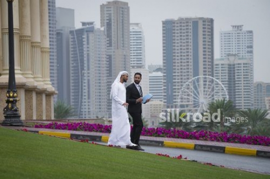 Middle Eastern Businessmen walking outside talking to each other|-