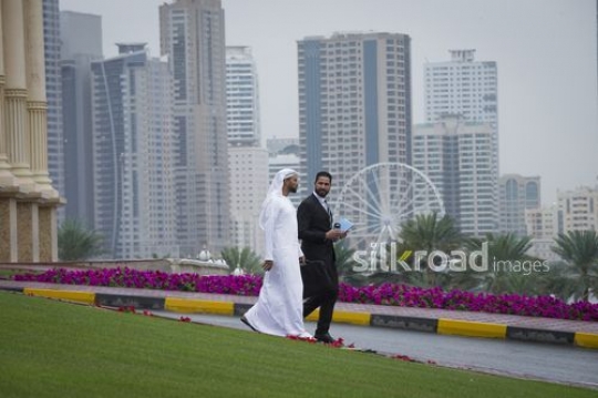 Businessmen walking outside talking to each other|-