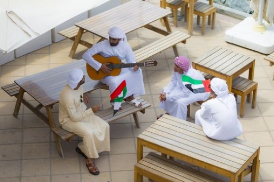 Top view of a group of men dressed in the traditional UAE attire celebrating National Day|