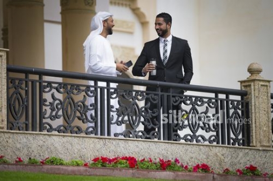 Arab Businessmen standing on the bridge talking to each other|-