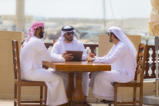 Arab men sitting outside during a business meeting|