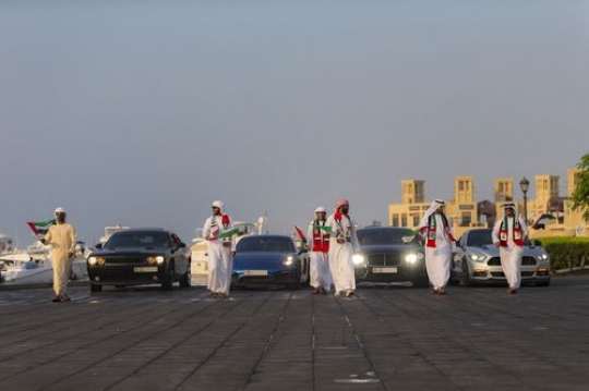 A National Day Parade focused on Emirati men and luxury cars|-