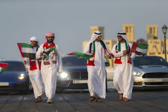 Friends and Family followed by luxury cars during the UAE national day parade|-