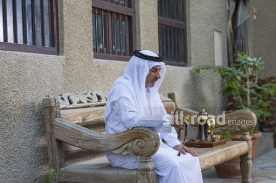 Middle eastern grandfather praying using his Misbahah|-