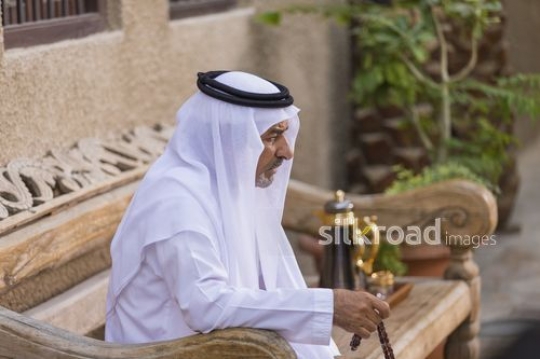 Arab man sitting on the bench with a misbahah in his hand|-