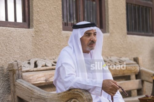 Arab man sitting on the bench with a misbahah in his hand|-
