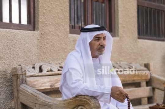 Arab man sitting on the bench with a misbahah in his hand|-