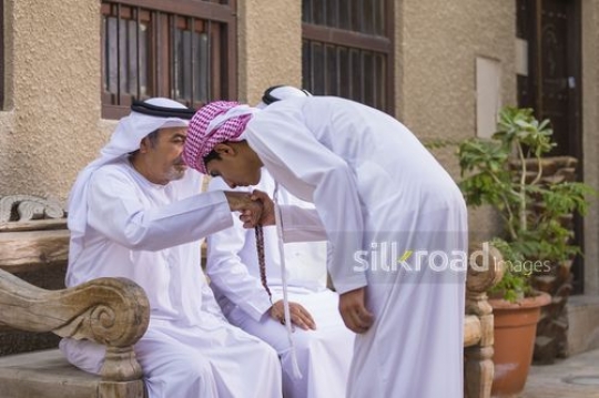 Arab son showing respect to his grandfather|-