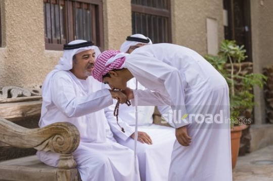 Arab son kissing grandfathers hand|-
