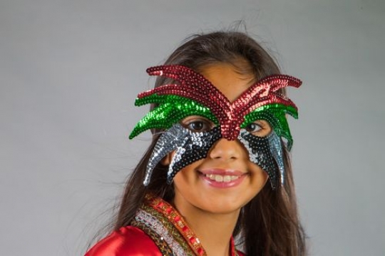 Young Middle Eastern girl wearing a mask celebrating National Day