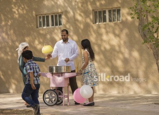 Arab boy taking cotton candy from the man|-