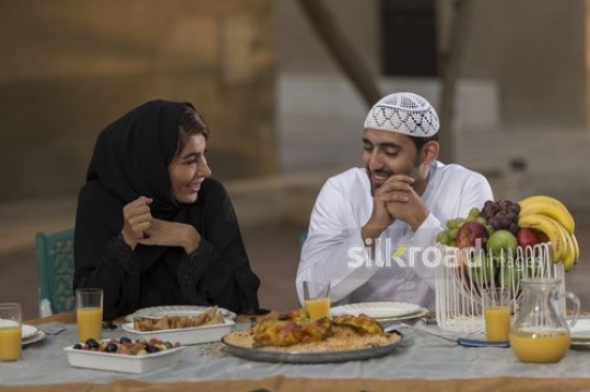 Arab man and woman sitting together during dinner|-