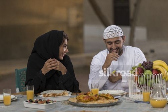 Arab woman and man sitting together during dinner|-