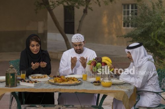 REPLACE - Middle Eastern family praying together before Iftar|-