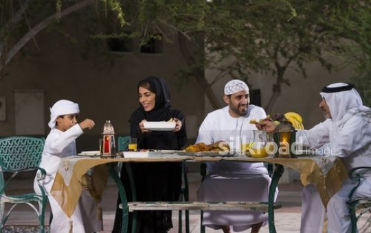 REPLACE - Arab family sitting on the table together having Iftar|-