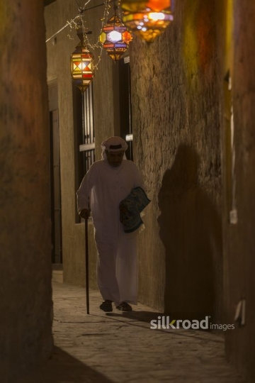 Arab man walking through the alleyway of Ramadan Lanterns|-