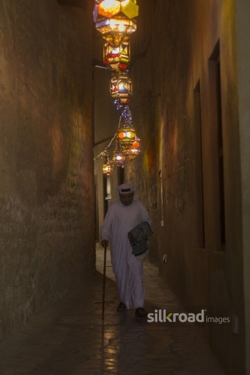 Arab man walking through the alleyway of the Ramadan Lanterns|-