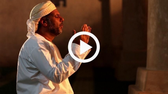 Old man raising his hands during prayer