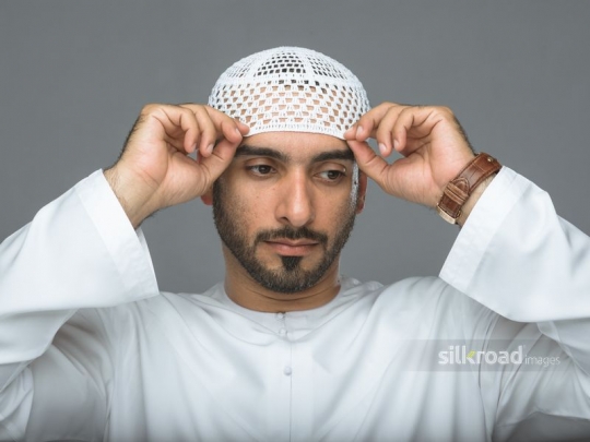Man fixing traditional cap
