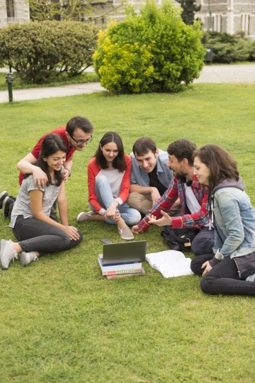 Group of students looking at something on the laptop