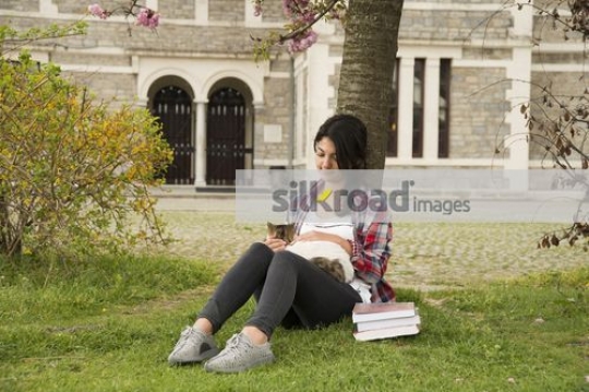 University Student sitting on campus with the cat|