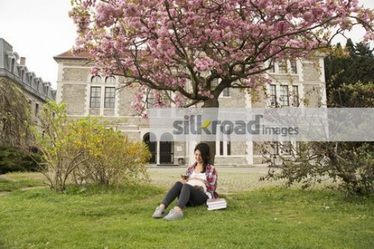 University Student sitting on the grass with the cat|