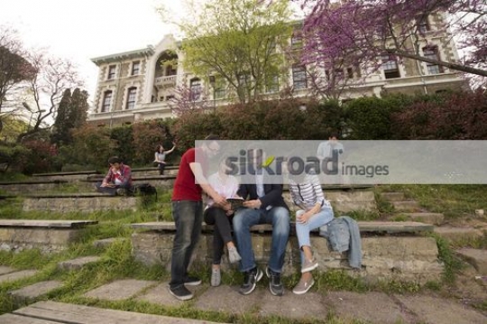 Group students sitting talking to the professor|