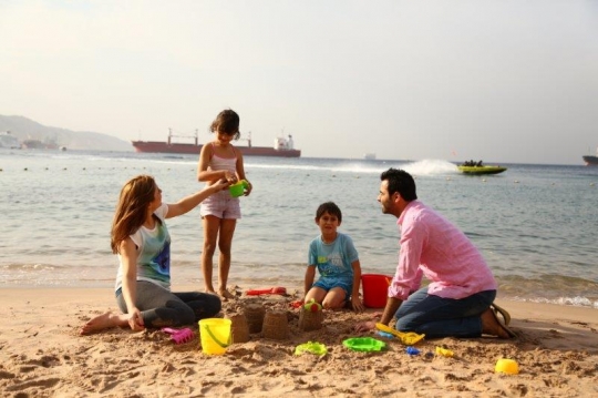 Family Having Fun By The Beach