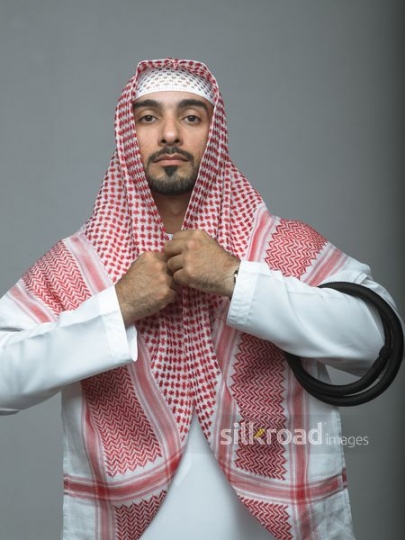 Arabian man fixing his traditional attire