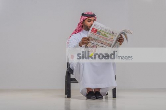 Businessman sitting reading the newspaper 