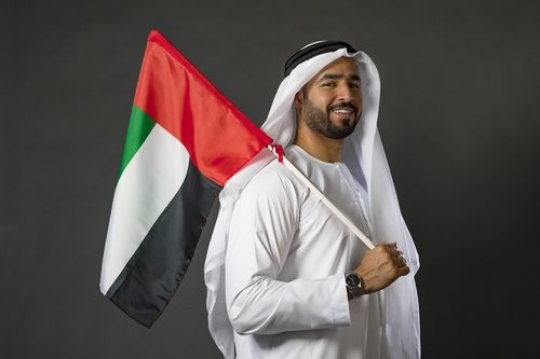Arab man carrying the UAE flag