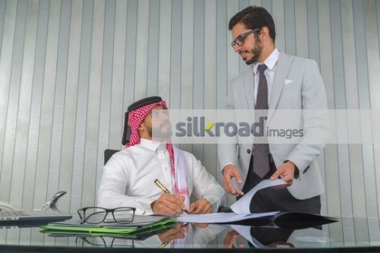 Middle Eastern employee talking to the boss at the office |